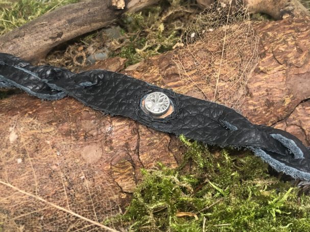 Lederarmband Mystery Braid Lederarmband mit in der Mitte eingenähtem Charm, zu beiden Seiten sind geflochtene Enden, der Verschluss ist ein Mönchskopfverschluss